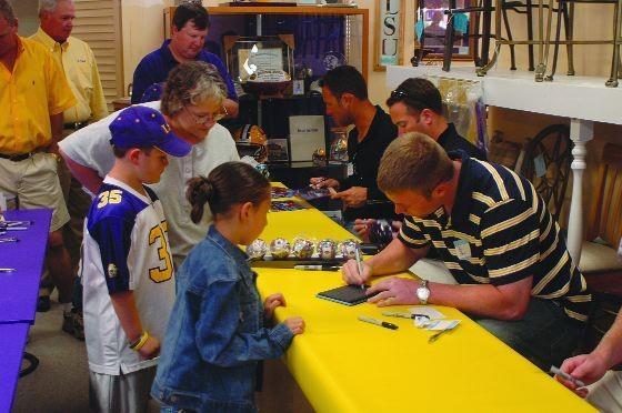 Alumni athletes sign autographs at furniture store