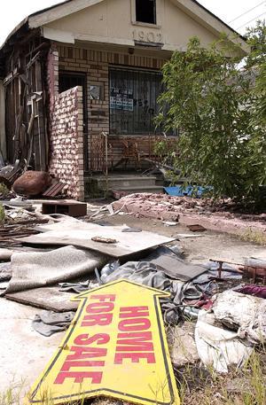 Two contradicting signs are displayed at a destroyed home in the Lower Ninth Ward Saturday, August 19. One sign says, 