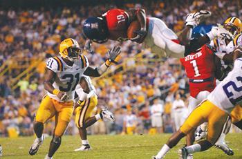 Arizona junior running back Chris Henry (19) goes airborne after he was upended by LSU junior cornerback Chevis Jackson (21) during the third quarter of the TIgers' 45-3 win over the Wildcats. LSU senior strong safety Jessie Daniels (31) finished the play by tackling Henry in mid-air before slamming him into the turf.