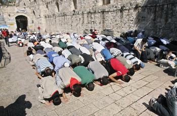 Muslims pray at the Lion's Gate during Ramadan Friday prayers outside the Al Aqsa Mosque in Jerusalem's Old City on Friday. Hundreds of Palestinians rioted and clashed with Israeli forces at checkpoints around Jerusalem on Friday after authorities blocked them from entering the city to mark the Ramadan holy month at Islam's third-holiest site.