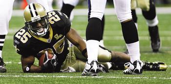 New Orleans Saints running back Reggie Bush grimaces in pain from a sprained ankle after being tackled by Baltimore Ravens Bart Scott in the second half of the Saints' 35-22 loss Sunday. Bush left the field and did not return to the game.