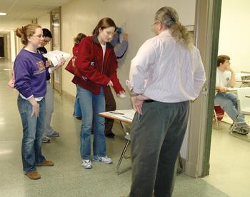 Regina Depree, a history senior, shows her identification and signs her name before entering the Coates Hall classroom to take the LSAT as Daily Reveille columnist Jack Collens waits inside.