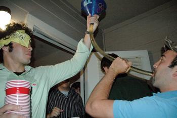 Stephen Paternostro, kinesiology junior, holds a beer funnel for Corey Englade, construction management senior, Friday night at a party in the University Crescent apartments. A new study indicates that the intensity of student drinking is on the rise.