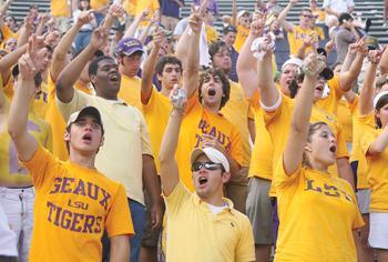 LSU students Dillon Couvillon (center), mass communication junior, and Kelly Landry (right), mass communication senior, cheer Sept. 30 at the Gold Game against Mississippi State University. LSU plays Virginia Tech on Sept. 8.