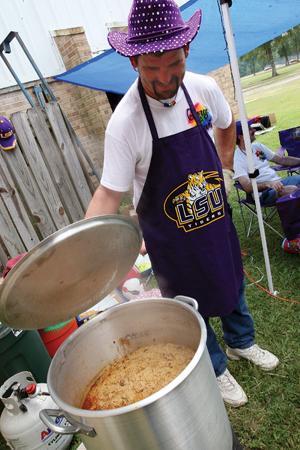 George Outlaw, field supervisor for Outlaw Industries, checks a pot of jambalaya Saturday afternoon before serving it at the Gay Pride Festival picnic in Forest Park. The Metropolitan Community Church hosted picnic guests to food, games, information booths and free HIV testing.