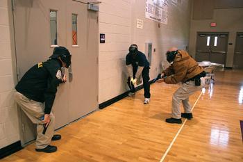 Police officers prepare to enter the Woodlawn High School gymnasium on Wednesday afternoon as part of a training exercise dealing with the threat of an active shooter.