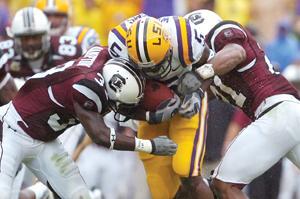 LSU running back Keiland Williams (middle) plows between South Carolina safeties Chris Hampton (33) and Emanuel Cook (21) during Saturday's matchup in Tiger Stadium.