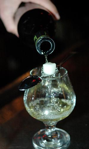 Randall Harrison, manager of Red Star, pours a glass of Lucid Absinthe over a sugar cube held on a spoon specially made for serving the liquor Wednesday night at the downtown bar. Absinthe, until recently, was illegal for several decades.