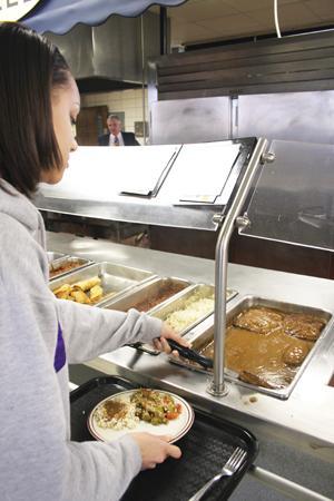 Melinda Hunter, biological engineering freshman, scoops a slab of meatloaf onto her plate Thursday afternoon in the Pentagon Dining Hall.