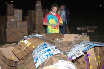 Andy Murray, electrical engineering freshman, repairs the roof of his box structure Saturday night on the field in front of the Natatorium. Students built houses out of boxes as part of "Sleep in a Box," a program to raise homeless awareness.