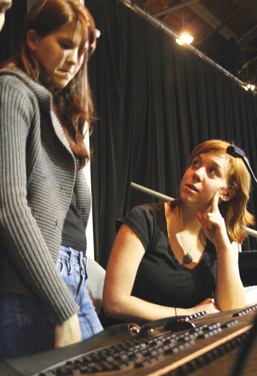 Amanda McLindon and Nichole Ingalsbe, theater juniors, discuss lightboard and backstage operation at the Swine Palace. Both students work behind the scenes of plays without pay.