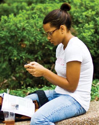 Hailey Branch, English junior, texts on her phone in the Quad on Monday morning.