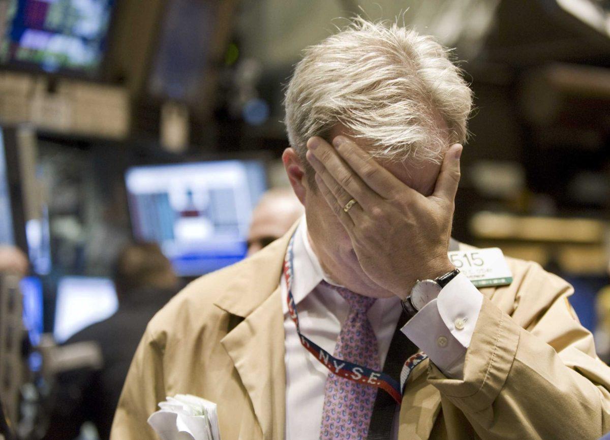 Trader David O'Day rubs his eyes as he works on the floor of the New York Stock Exchange on Monday.