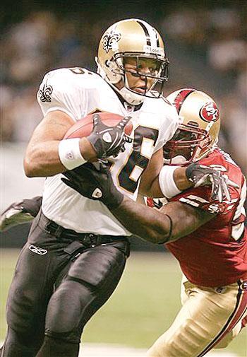 New Orleans Saints running back Deuce McAllister (26) tries to outrun San Francisco 49ers defender Patrick Willis, right, in New Orleans on Sunday.