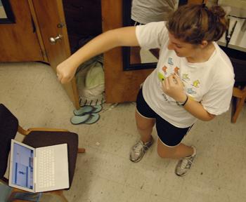 Megan Cockfield, pre-nursing freshman, follows along with the online UREC kickboxing video on her laptop Tuesday afternoon. University recreation has recently begun offering online workout videos for students.