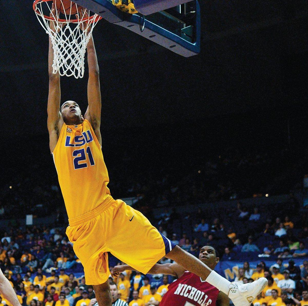 Senior Chris Johnson, center, makes a slam dunk goal at the intrasquad scrimmage Monday in the PMAC. The scrimmage is LSU&#8217;s first attempt to bring in fans to support the team, which coach Trent Johnson says will pick up its weight this season.