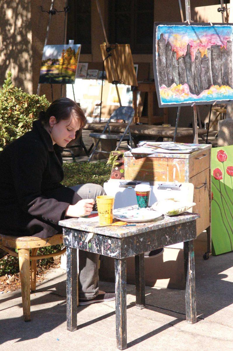 Jessica Ramsey, studio art junior, paints Friday afternoon during &#8220;The Christmas Show&#8221; held in front of Foster Hall.