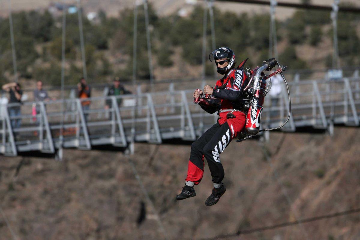 Eric Scott flies next to the Royal Gorge Bridge while visitors look on in Canon City, Colo. on Monday.