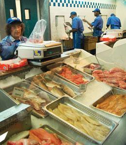 Janet Carreca, an employee at Tony&#8217;s Seafood, weighs seafood for a customer.