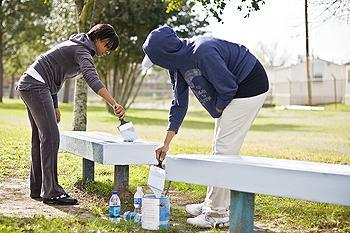 [Left] Alyssa Stewart, psychology sophomore, and [right] Kiara Fuller, biology sophomore, paint benches outside Buchanan Elementary on Monday morning.