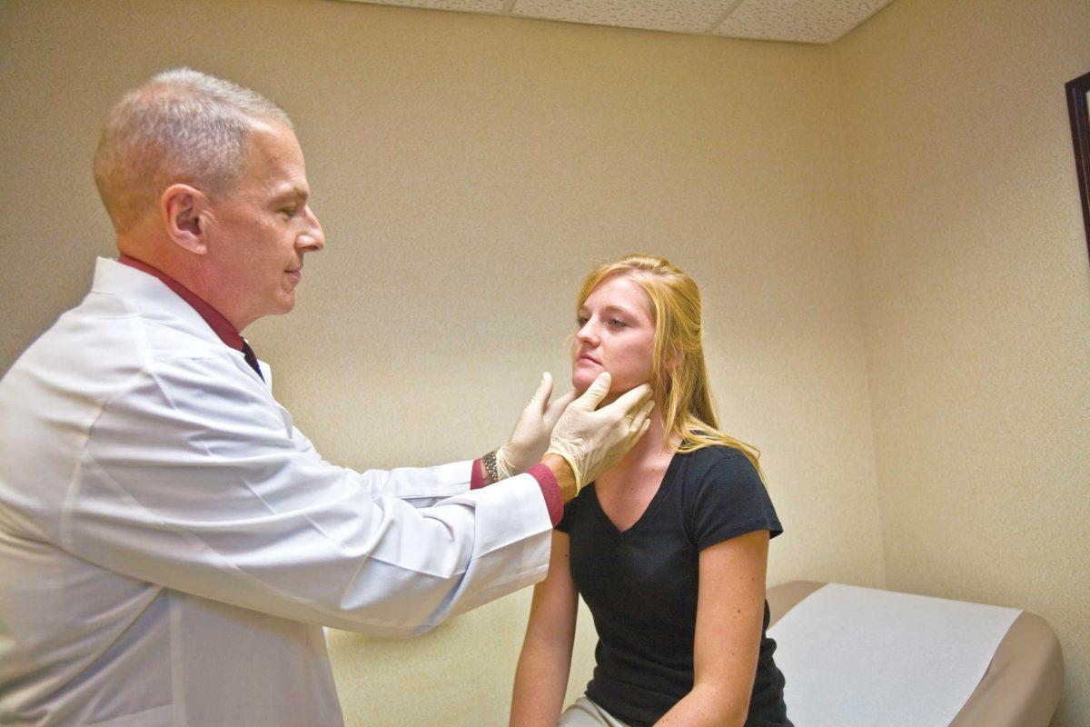 Dr. Timothy Honigman checks University alumna Amanda Glass at the Student Health Center. The Health Center reported a February peak in flu-positive patients.