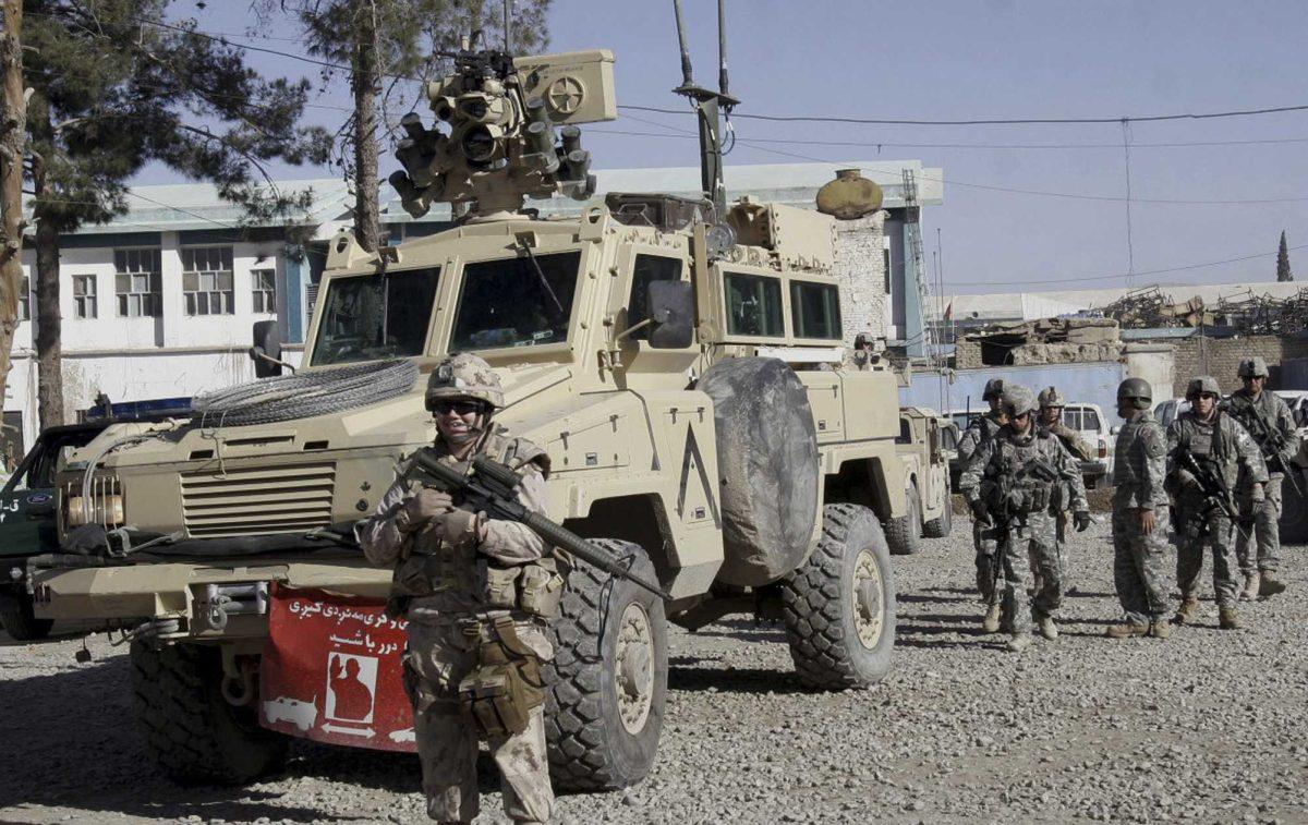 A U.S. soldier stands guard in front of an armored personal carrier Sunday in Kandahar, Afghanistan.