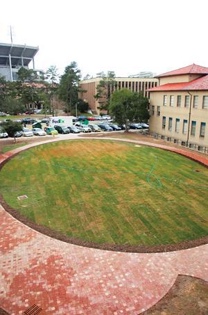 A sprinkler waters the newly laid grass Monday afternoon in the lot behind Dodson Auditorium.