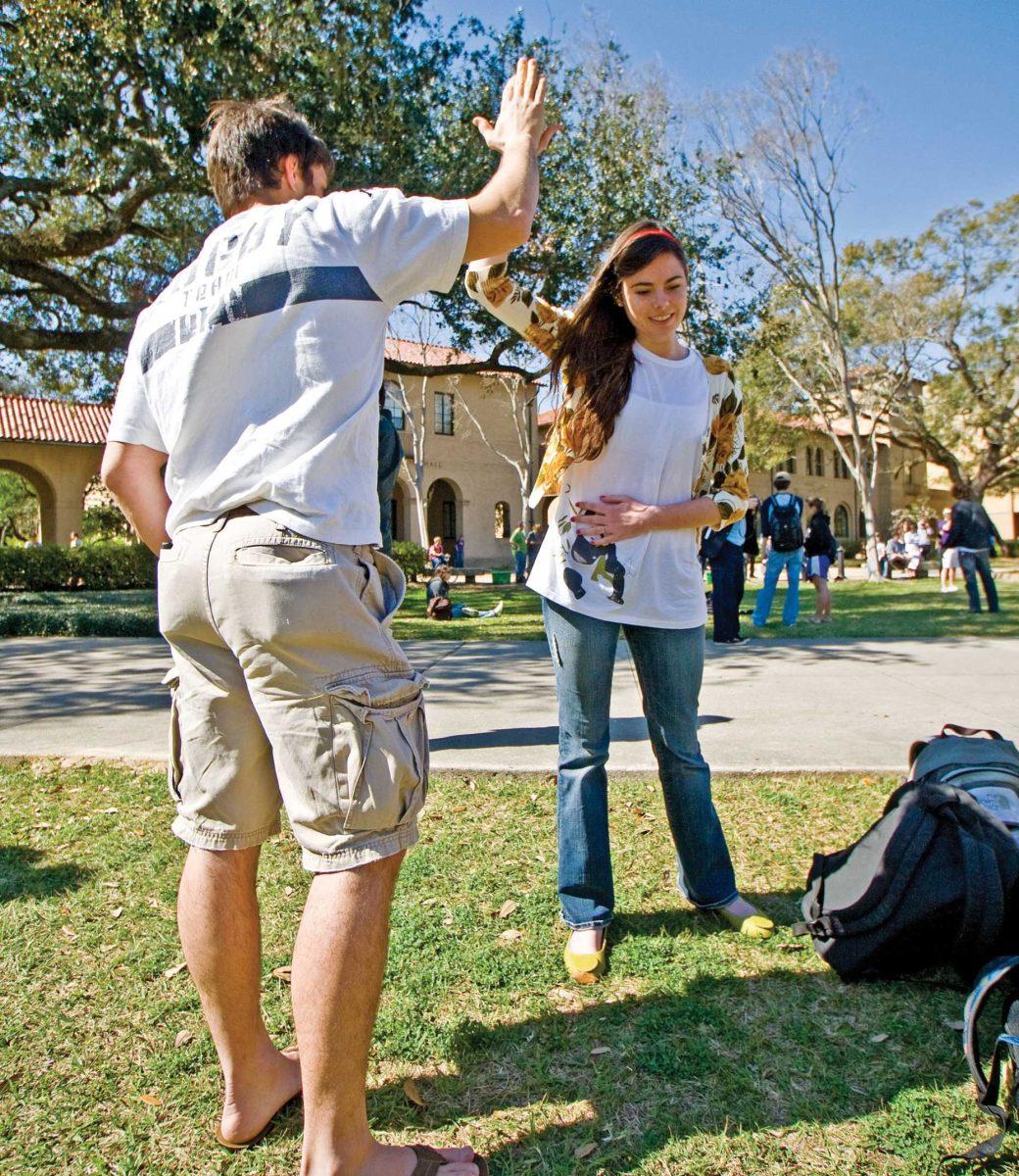 Rachel Zimmerman (right) stands in a high-five pose with a friend in the Quad on Thursday afternoon during the five-minute flash mob project.