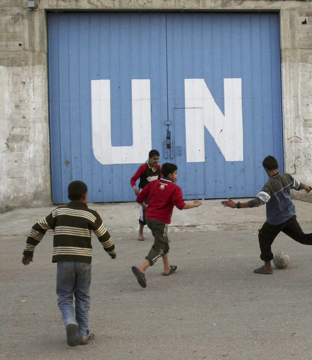 Palestinian children play soccer in front of the gate of a United Nations food distribution center in Gaza City, Friday, Feb. 6, 2009. The U.N. agency for Palestinian refugees said Friday that it has halted all aid shipments into the Gaza Strip due to interference by the ruling Hamas militant group. The U.N. Relief and Works agency said it made the decision after Hamas personnel intercepted an aid shipment for the second time this week.