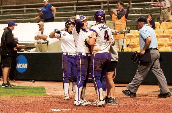 Freshman Juliana Santos and junior Rachel Mitchell congratulate freshman Morgan Russel on her home run March 11 and celebrate their 4-3 win against Baylor.