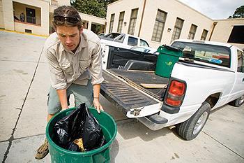 Matthew Moerschbaecher, Oceanography PHD student, picks up waste from 459 Commons to take to a local compost pile Tuesday afternoon.