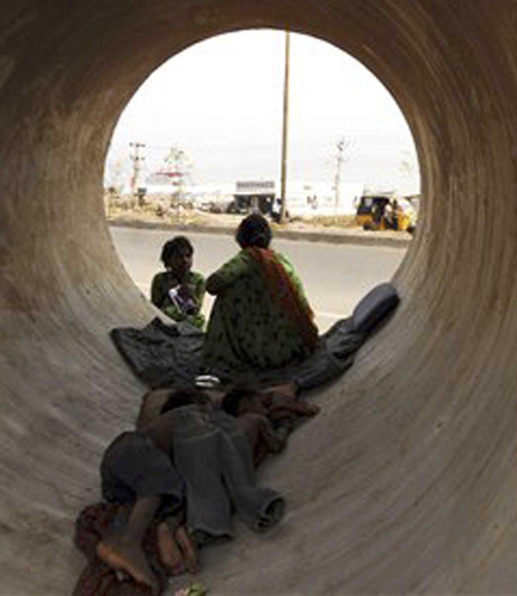 Homeless children sleep inside a concrete pipe on the outskirts of Hyderabad, India, Friday, March 20, 2009. About 65 million Indians, roughly a quarter of the urban population, live in slums, according to government surveys. Health care is often nonexistent, child labor is rampant and inescapable poverty forms the backdrop of everyday life.