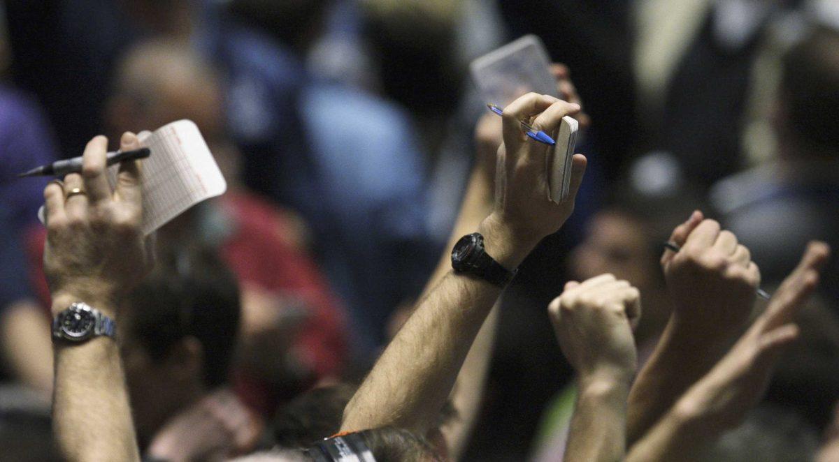 Traders hold up their hands Monday in the S&amp;P 500 futures pit near the close of trading at the CME Group in Chicago.