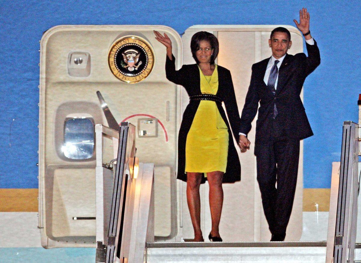 President Obama and first lady Michelle Obama wave as they walk down the steps from Air Force One Tuesday at Stansted Airport.