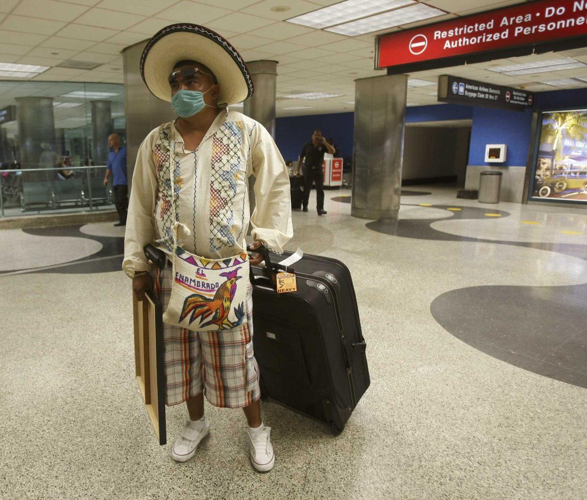 Marco Lugo walks through the Miami International Airport on Monday after arriving on a flight from Mexico City for a family visit.