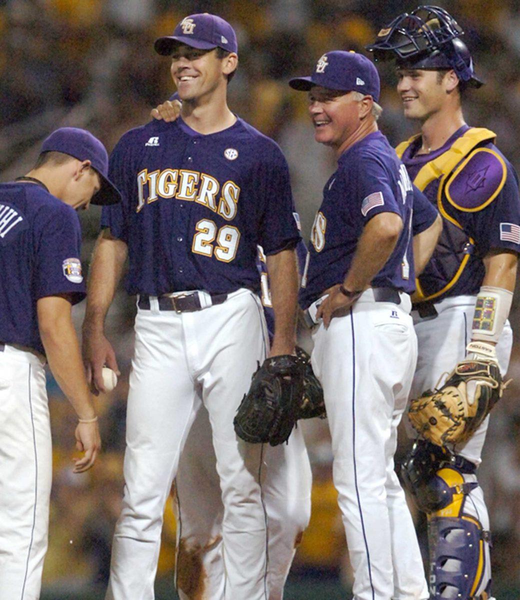 [Left to right] LSU senior third baseman Derek Helenihi, senior pitcher Louis Coleman, coach Paul Mainieri and sophomore catcher Micah Gibbs smile as Mainieri pulls Coleman from the game in the bottom of the seventh inning. Coleman allowed one run and struck out eight batters in 7 2/3 innings for the win in the Tigers' 10-3 victory.