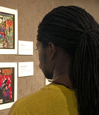 Cornelius Toole, comic fan and computer science graduate student, views comic art in the Union Art Gallery Wednesday evening. The Union Art Gallery is hosting the exhibit &#8220;Kapow!