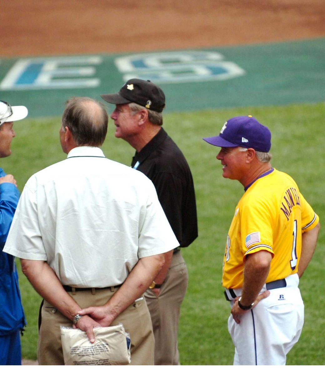 LSU coach Paul Mainieri talks with NCAA officials Friday during a rain delay prior to the Tigers' College World Series matchup with Arkansas in Omaha, Neb.