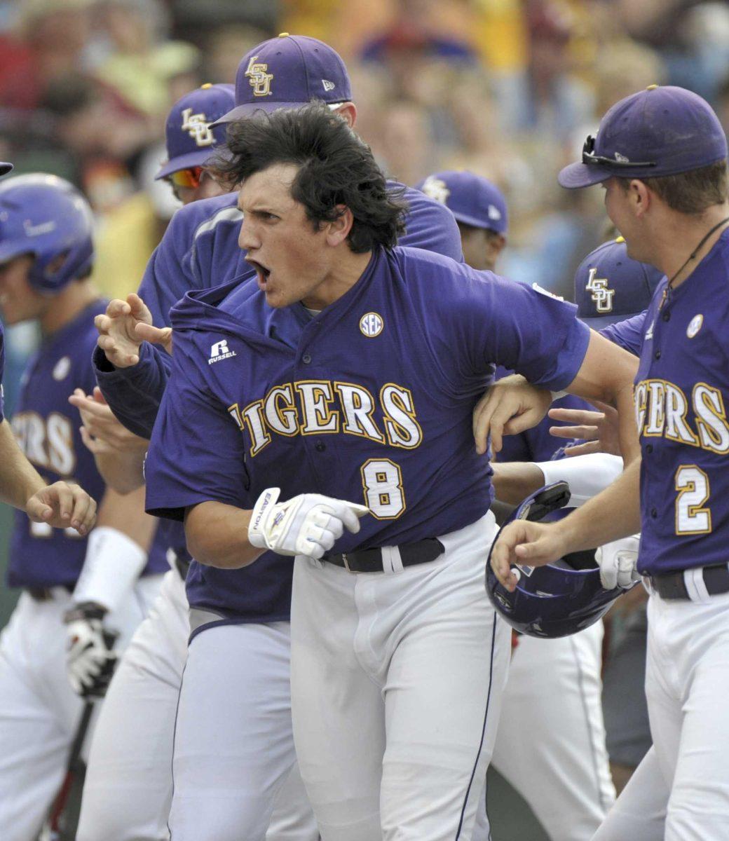 LSU's Mikie Mahtook celebrates with teammates after he hit a three-run home run against Arkansas in the first inning of an NCAA College World Series baseball game in Omaha, Neb.