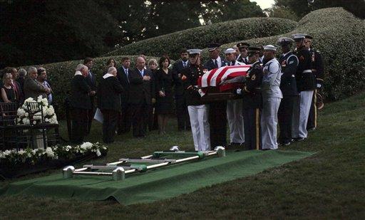 The Kennedy family gathers around the grave site as an Honor Guard carries the casket of Sen. Ted Kennedy at Arlington National Cemetery, in Arlington, Va. on Saturday, Aug. 29, 2009. Kennedy's remains will be buried alongside his slain brothers, John and Robert.