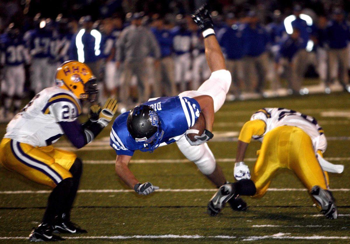 Ocean Springs, Miss., fullback Travis Dickson is tripped by defensive backs during a 2007 5A state playoff game. His brother, Richard, is a starting tight end for the Tigers.