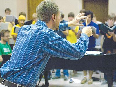 Chorus conductor Brian Kittredge [center] leads rehearsal Wednesday.