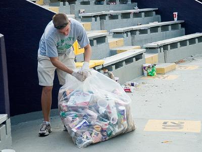 Bryce Bawcom, sociology junior, ties a garbage bag while cleaning in Tiger Stadium on Sept. 20. Trash is currently sent to a landfill, but a recycling program is being implemented.