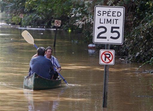 Ben Prince, facing forward, paddles his neighbor David Bush down the street they both live on in Atlanta after surveying damage to their homes Tuesday, Sept. 22, 2009. Heavy rains caused flooding in Atlanta.