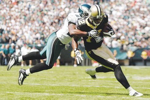 Saints wide receiver Marques Colston, right, is tackled by Eagles cornerback Sheldon Brown in the first quarter of the Saints&#8217; 48-22 win Sunday.