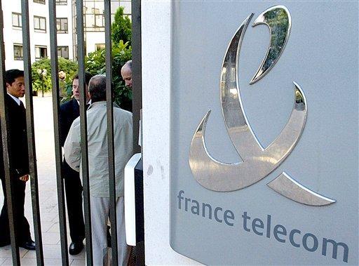 FILE - In this Sept. 13, 2002, file photo people stand by the entrance to the headquarters of France Telecom SA in Paris. France Telecom SA is mobilizing all 20,000 of the company's managers Monday Sept. 14, 2009 in an effort to respond quickly to a series of employee suicides that unions blame partly on layoffs and restructuring at the telecommunications giant.