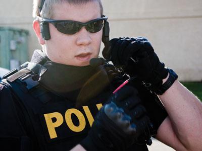 LSUPD officer Daniel Richardson demonstrates a communication headset Thursday.