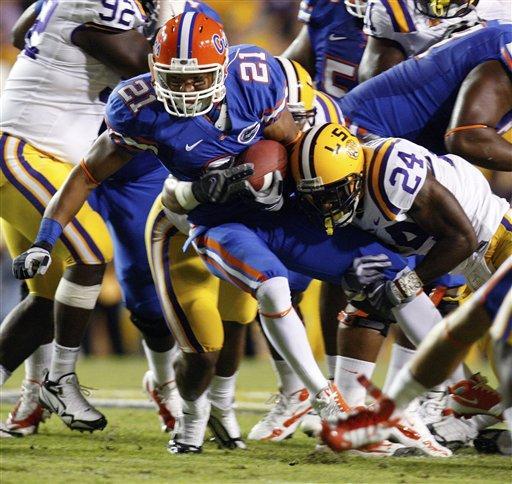 Florida wide receiver Chris Tolliver (21) is stopped by LSU linebacker Harry Coleman (24) in the first half of an NCAA college football game in Baton Rouge, La., Saturday, Oct. 10, 2009.