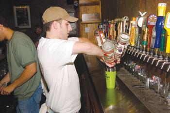 Bartender Anthony Ramirez mixes drinks for a group of patrons at The Bulldog on Perkins Road on Tuesday.