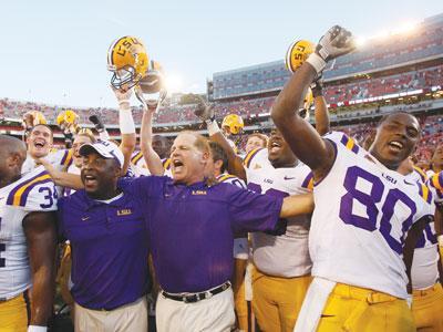 LSU coach Les Miles, center, celebrates the Tigers&#8217; victory Saturday with running backs coach Larry Porter, left, and junior wide receiver Terrance Toliver, right in Athens, Ga.